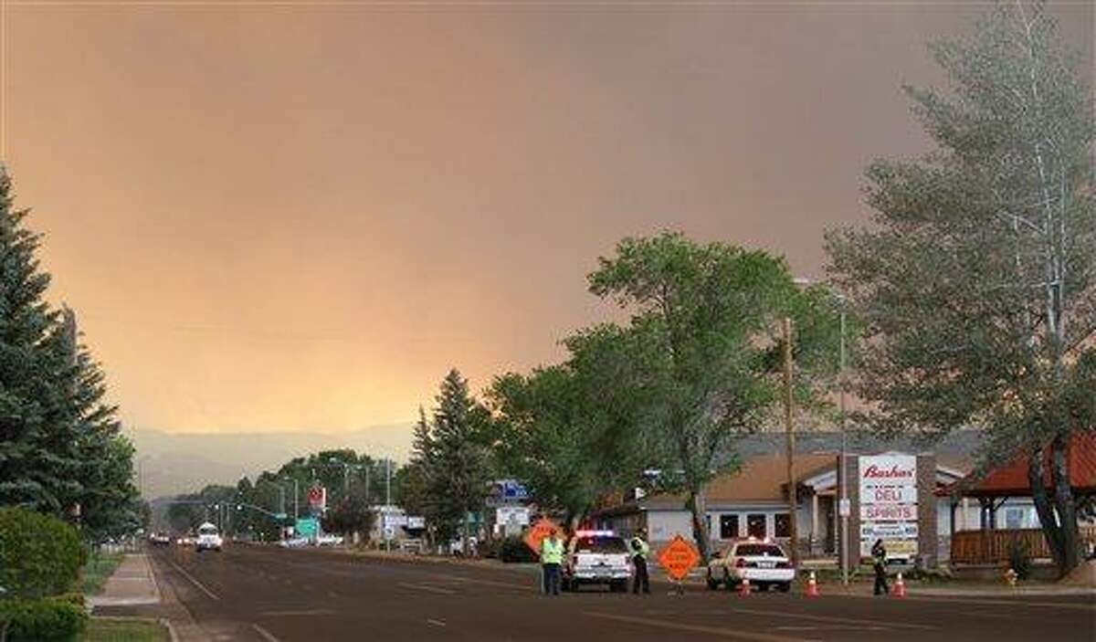 Authorities block the road heading to the southern half of Eagar, Ariz., after the Wallow Fire forced evacuations in part of the community on Tuesday, June 7, 2011. Flames from a mammoth forest fire licked the ridges surrounding the eastern Arizona town Tuesday afternoon, forcing the evacuation of about half the 4,000 residents as surrounding towns also prepared to empty. (AP Photo/Susan Montoya Bryan)