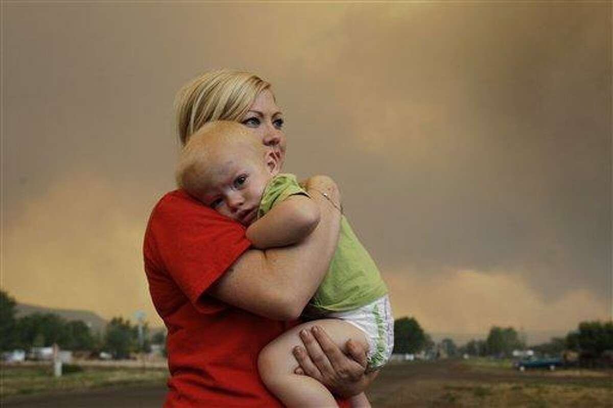Emily Shupe comforts her 18-month-old son Jax as the family prepares to evacuate to Phoenix as the Wallow fire approaches in Springerville, Ariz., Tuesday, June 7, 2011. The blaze has burned 486 square miles of ponderosa pine forest, driven by wind gusts of more than 60 mph since it was sparked on May 29 by what authorities believe was an unattended campfire. It officially became the second-largest in Arizona history on Tuesday. (AP Photo/Marcio Jose Sanchez)