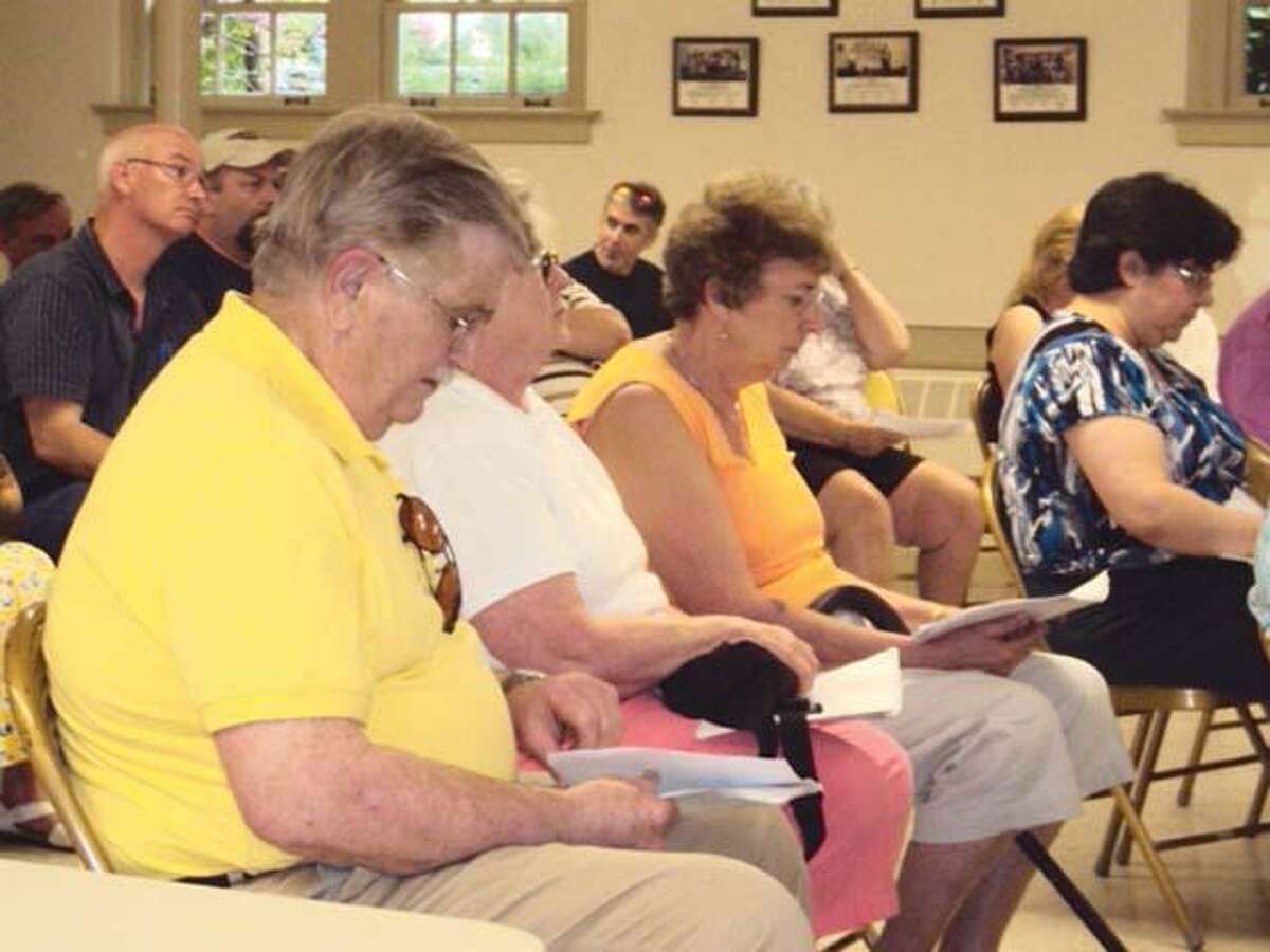 RICKY CAMPBELL/ Register CitizenVoters in Morris flip through the budget hand out during Wednesday's town meeting. The residents voted unanimously to approve the budget for 2011-12.