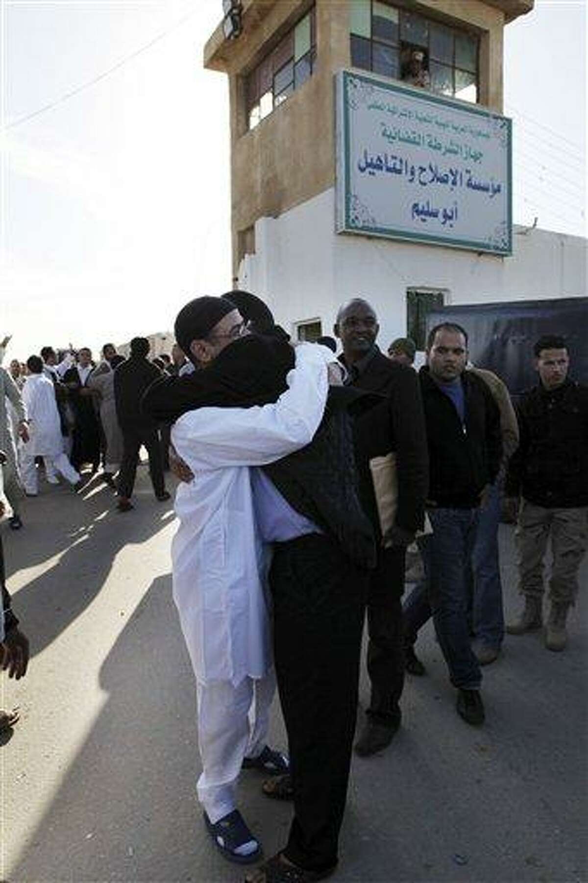 A Libyan prisoner, left, is hugged by his relatives after he was released with a group of 110 prisoners from Abu Salim, Libya's most notorious prison, in Tripoli, Libya, Wednesday, Feb. 16, 2011. Egypt-inspired unrest spread against Libya's longtime ruler Moammar Gadhafi on Wednesday, with riot police clashing with protesters in the second-largest city of Benghazi and marchers setting fire to security headquarters and a police station in the city of Zentan, witnesses said. Gadhafi's government sought to allay further unrest by proposing the doubling of government employees' salaries and releasing 110 suspected Islamic militants who oppose him tactics similar to those used by other Arab regimes in the recent wave of protests. (AP Photo/ Abdel Magid Al Fergany)