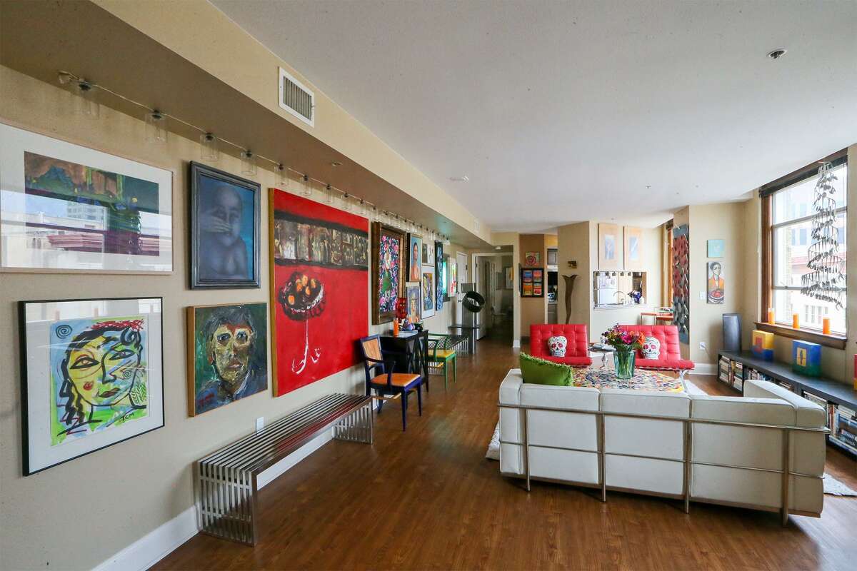 Art, mostly by local artists, fills almost every inch of a living room wall.