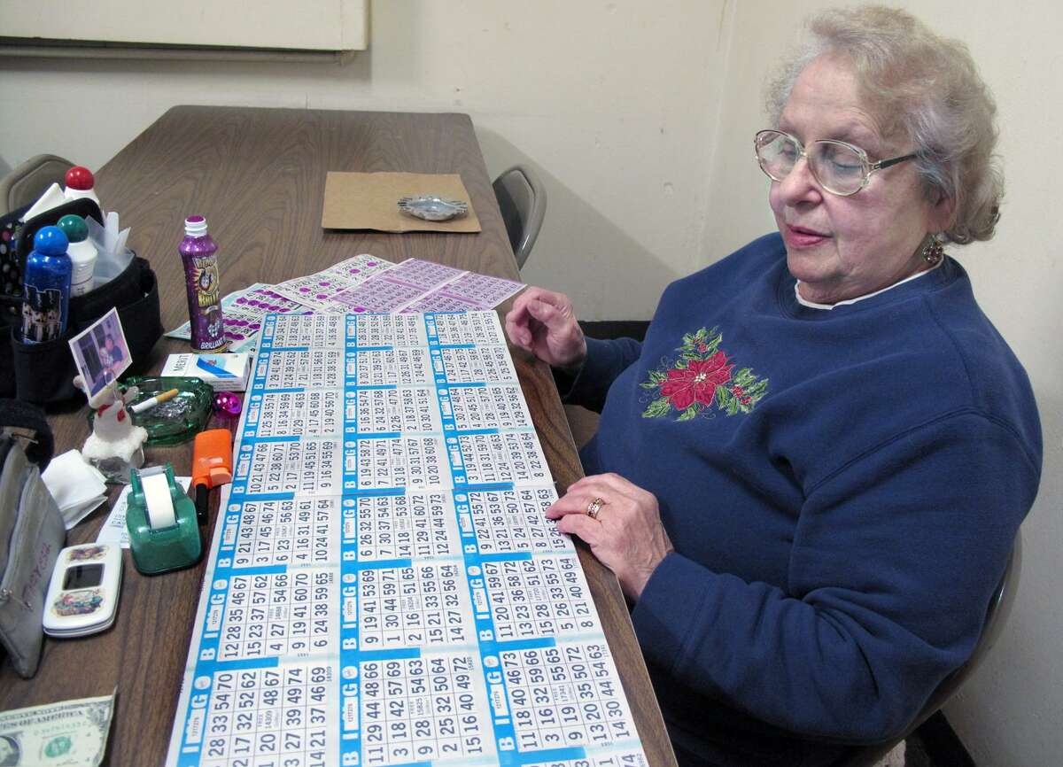 DEBBI MORELLO/Register Citizen Theresa Ross has been coming to St. Maron's Church to play Bingo for nearly 38 years. She is setting up her table at St. Maron's Church on Sunday.
