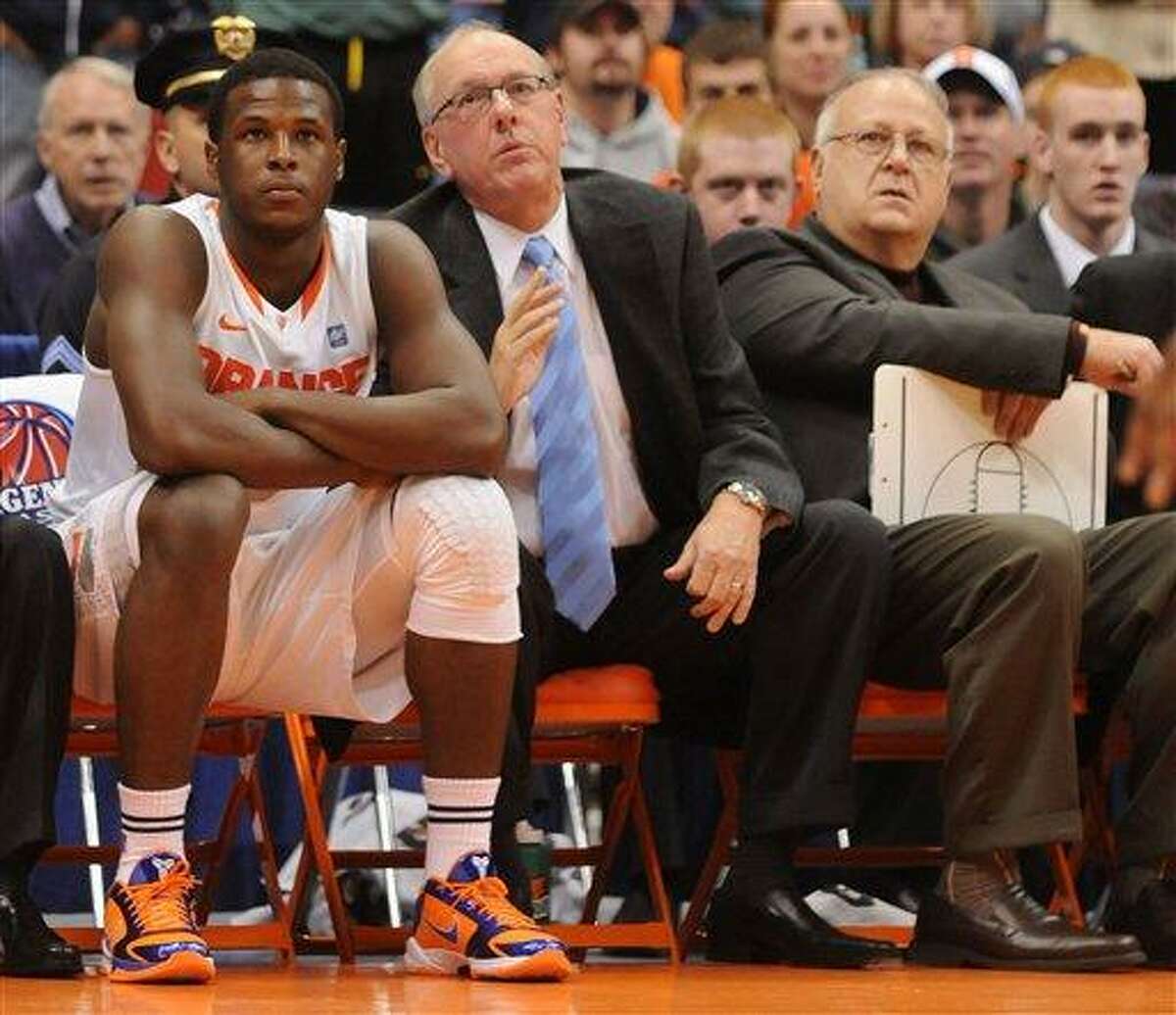 In this Nov. 21, 2010 file photo, Syracuse basketball player Dion Waiter, left, sits on the bench beside head coach Jim Boeheim, center, and assistant coach Bernie Fine, right, during a game against William & Mary, in Syracuse, N.Y. Fine was placed on administrative leave Thursday, Nov. 17, 2011 after old child molesting allegations resurfaced, just two weeks after a child sex abuse scandal rocked Penn State. (AP Photo/The Post Standard, Dennis Nett) INTERNET OUT TV OUT MAGS OUT NO ARCHIVE