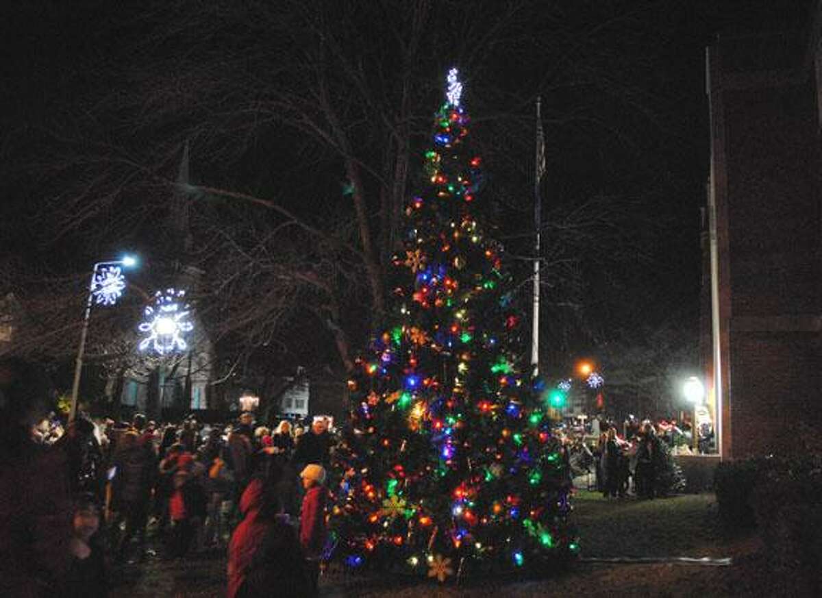 MIKE AGOGLIATI/Register Citizen Residents gather around the tree in Coe Memorial Park Friday night during Torrington's Light Up Main event.