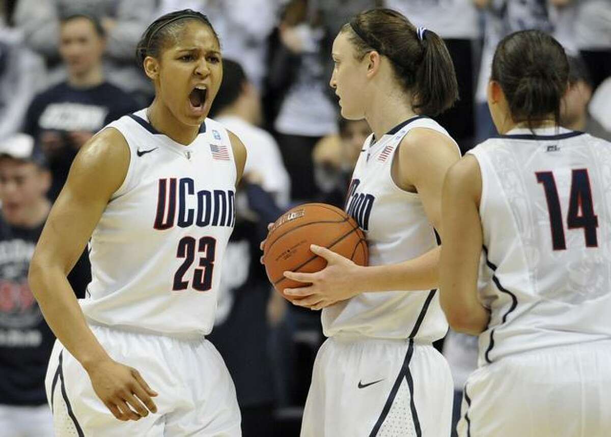 Connecticut's Maya Moore, left, reacts to a foul against Connecticut as teamamtes Kelly Faris, center, and Bria Hartley (14) look on, during the second half of an NCAA college basketball game against Notre Dame, in Storrs, Conn., Saturday, Feb. 19, 2011. (AP Photo/Jessica Hill)