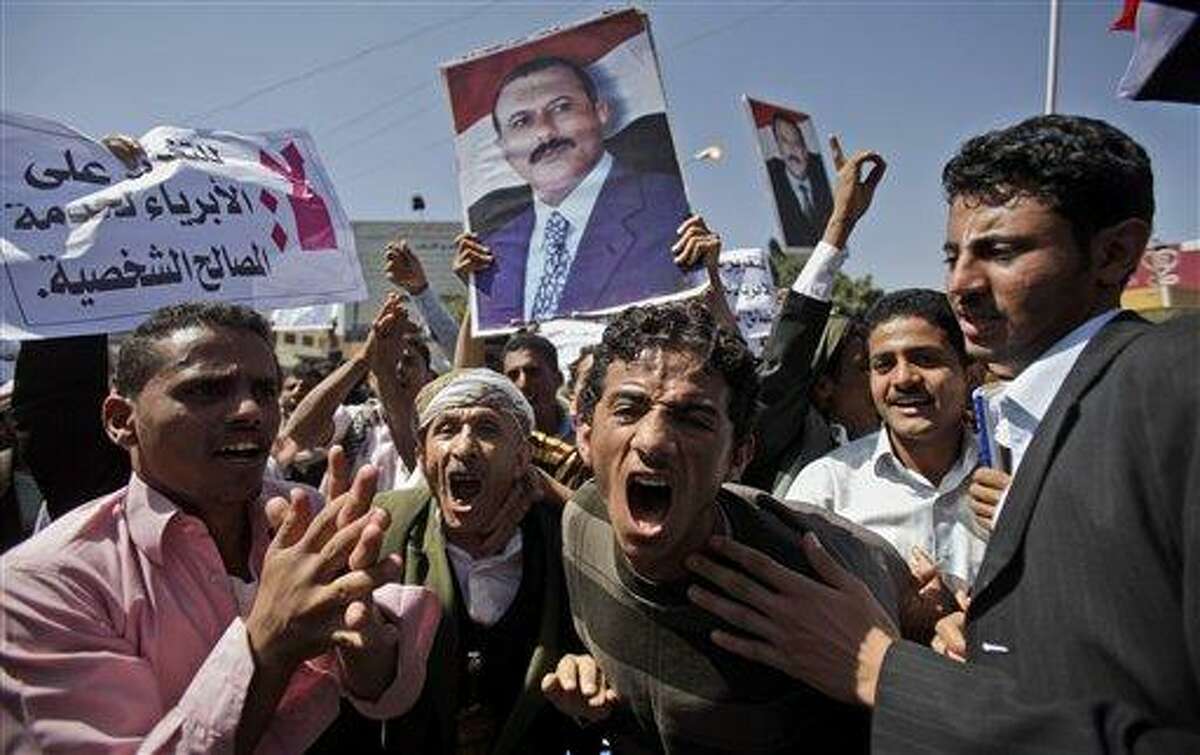 Supporters of the Yemeni government shout at anti government demonstrators, not pictured, in Sanaa, Yemen, Saturday, Feb. 19, 2011. Hundreds of Yemenis began demonstrating early in the morning Saturday outside the university in Sanaa demanding the ouster of the country's longtime ruler as they marched towards the Justice Ministry. "The people want the ouster of the regime," they chanted. (AP Photo/Muhammed Muheisen)