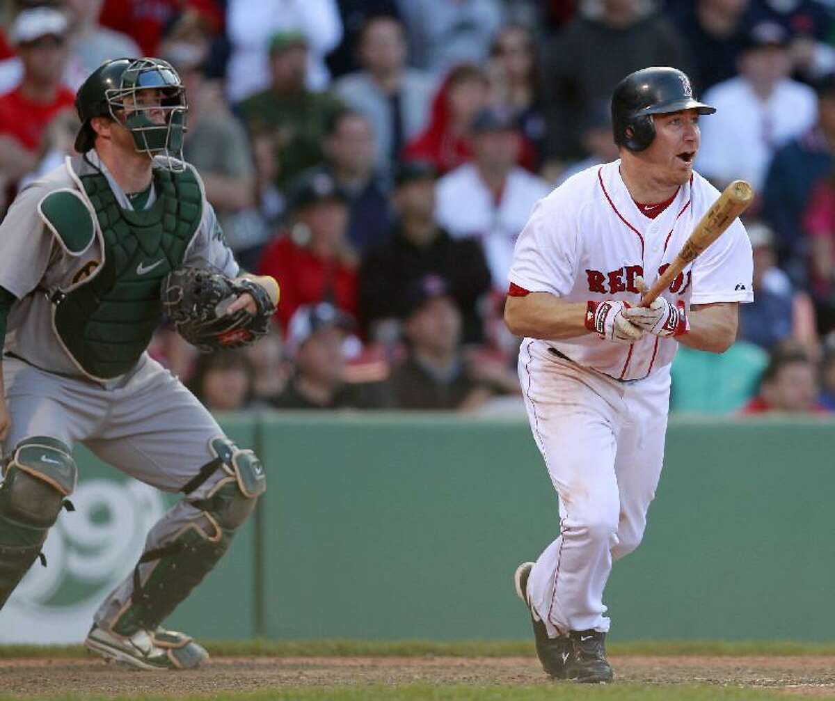 ASSOCIATED PRESS Boston's J.D. Drew, right, watches his game-winning RBI single in front of Oakland catcher Landon Powell in the 14th inning of Saturday's game at Fenway Park in Boston. The Red Sox won 9-8 in 14 innings.