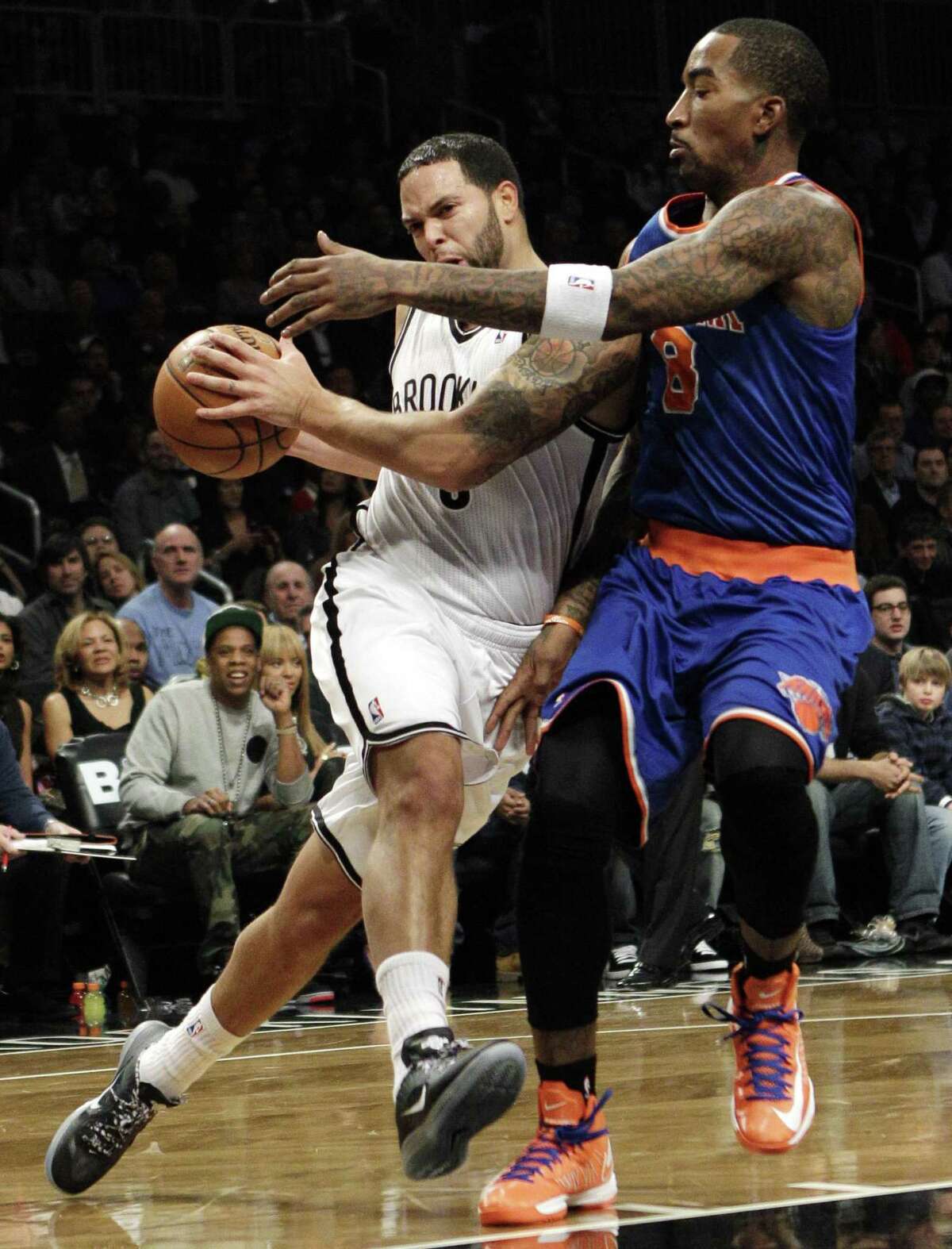 Brooklyn Nets guard Deron Williams attempts to drive around New York Knicks guard J.R. Smith. By The Associated Press