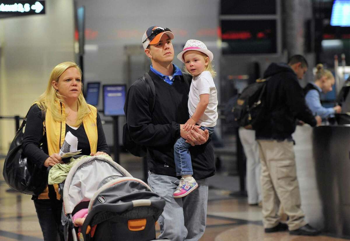 Jen Daley, left, pushes a stroller with daughter Sofia Daley while her husband Scot Daley, center, and daughter Scotlyn Daley, right, 3, all of Centennial, walk to their gate at Denver International Airport on Wednesday. They are traveling to Florida for the Thanksgiving holiday. Associated Press
