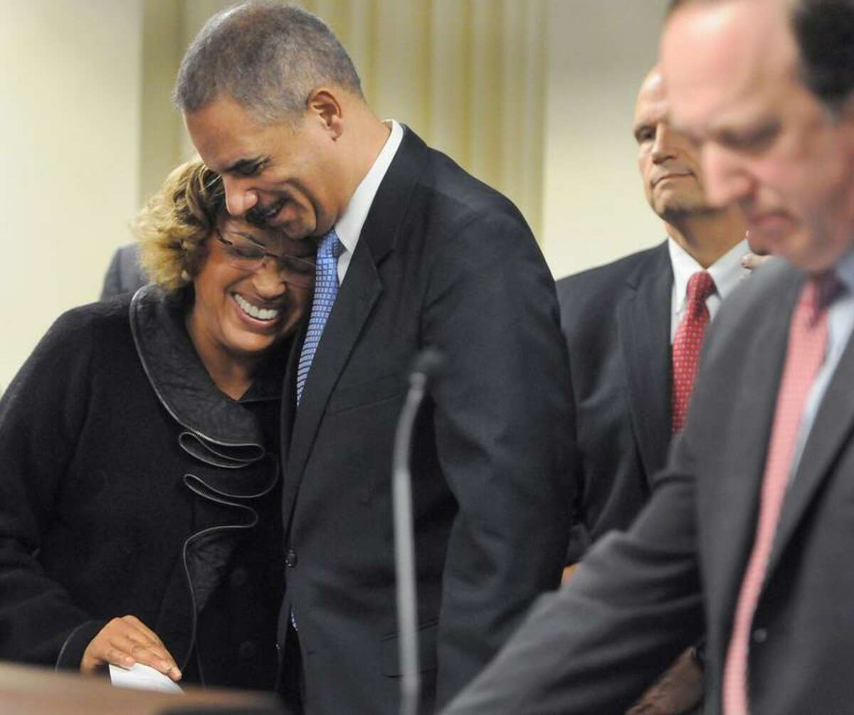 Alicia Caraballo, Adult Education Director for the New Haven Board of Education, left, is hugged by Attorney General Eric Holder after Caraballo shared the loss of her son n to gun violence in New Haven, Conn. during a press conference Tuesday, November 27, 2012 at the United States Attorney District of Connecticut Office in New Haven announcing the launch of Project Longevity, an initiative to reduce gun violence in Connecticut's major cities. At far right is United States Attorney for Connecticut David Fein. Photo by Peter Hvizdak / New Haven Register
