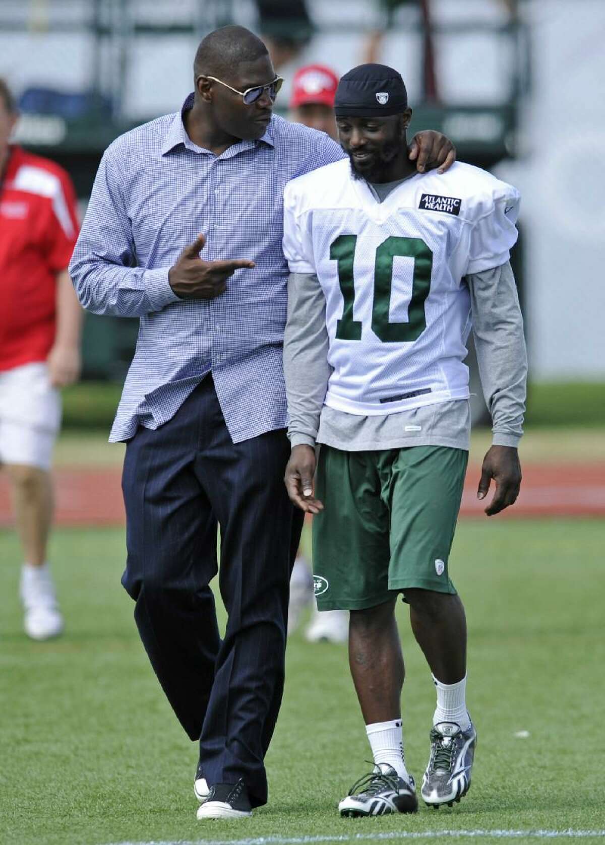 ASSOCIATED PRESS Former New York Jets receiver Keyshawn Johnson, left, talks with Jets wide receiver Santonio Holmes after practice on opening day of their training camp Friday in Cortland, N.Y.