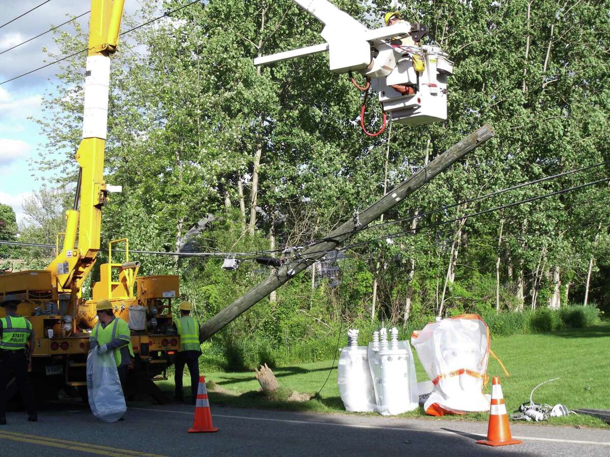 RICKY CAMPBELL/Register Citizen A power company crew works on Route 61 in Morris after winds knocked a pole and wires down, causing a power outage.