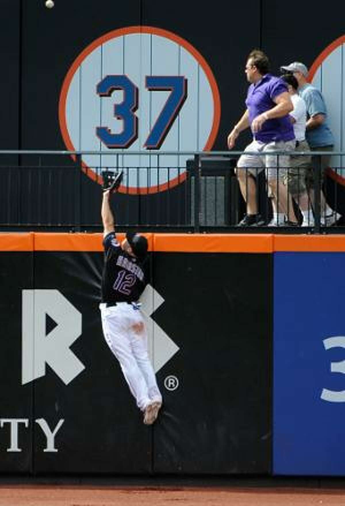 ASSOCIATED PRESS New York Mets left fielder Scott Hairston (12) leaps into the air to try to catch a two-run home run hit by Los Angeles Dodgers' Juan Uribe in the ninth inning of Saturday's game at Citi Field in New York. The Dodgers won 8-5.