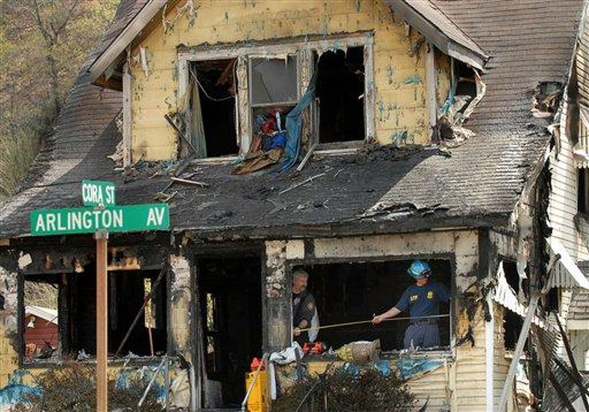 Investigators sift through debris in the aftermath of a house fire on Saturday in Charleston, W.Va. A fire tore through the two-story home that had no functioning smoke detectors, killing eight family members, including six children, Charleston Mayor Danny Jones said. Associated Press