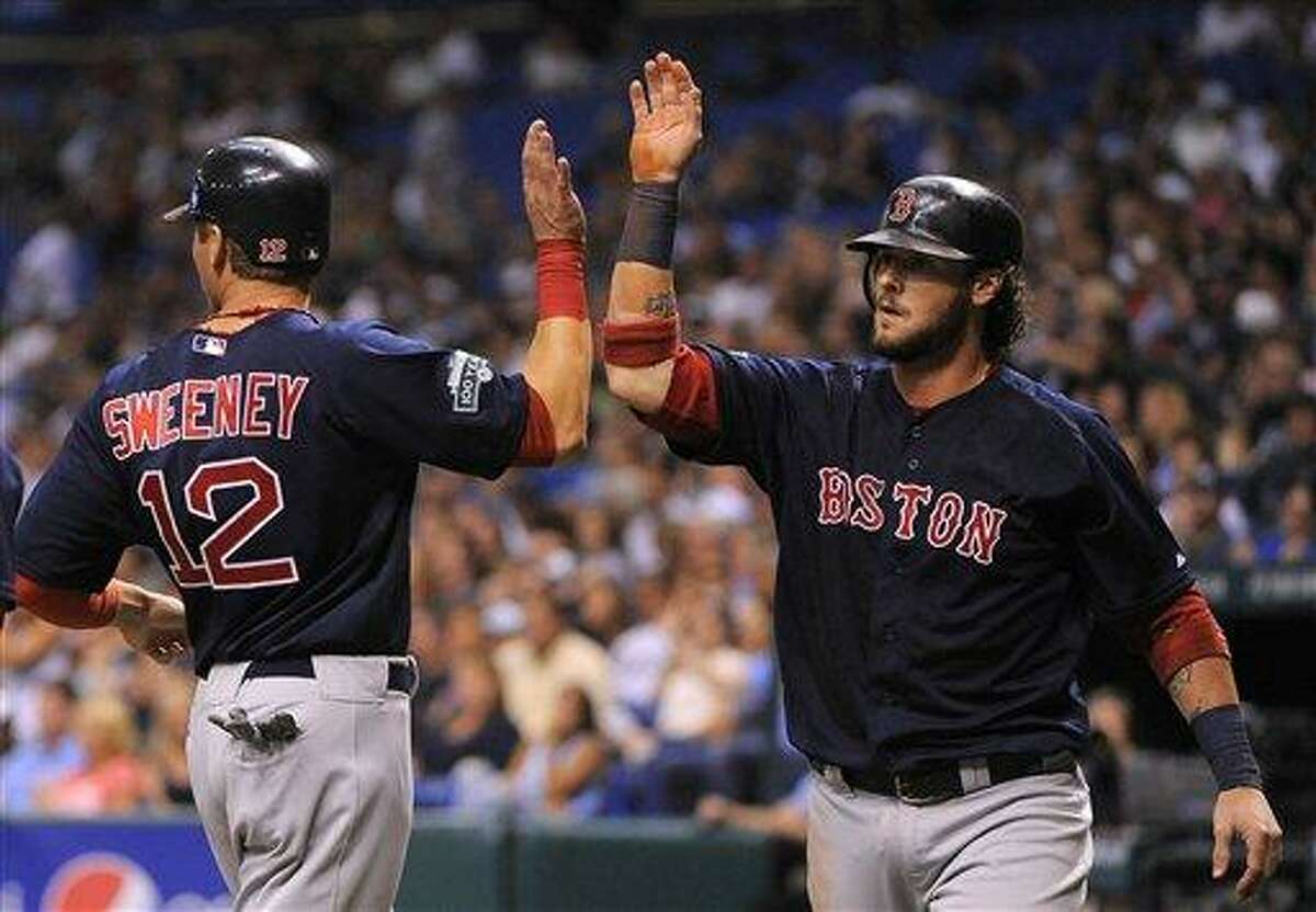 Boston Red Sox base runners Jarrod Saltalamacchia, right, and Ryan Sweeney celebrate at the plate after both scoring off of teammate Pedro Ciriaco's single off of Tampa Bay Rays starting pitcher Jeremy Hellickson during the second inning of a baseball game, Friday, July 13, 2012, in St. Petersburg, Fla. (AP Photo/Brian Blanco)
