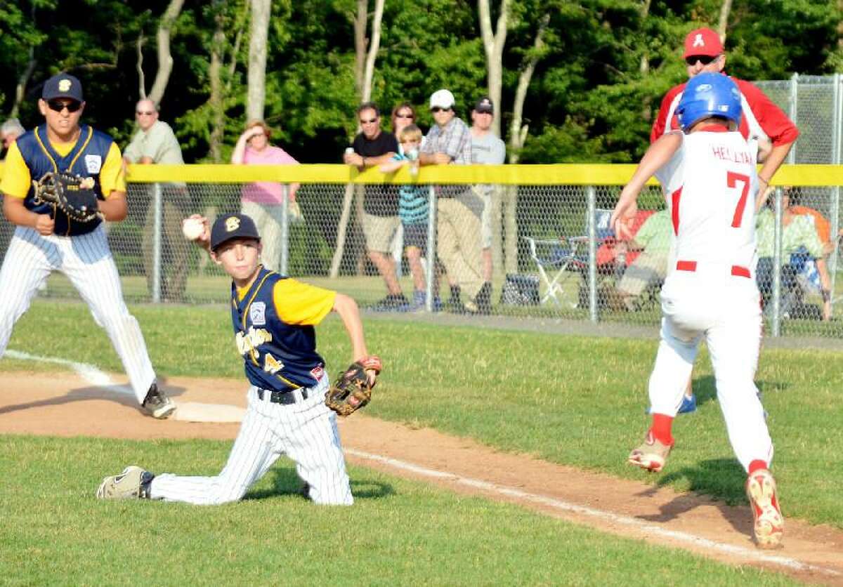 Gerry deSimas, Jr./Collinsville Press.com Burlington pitcher Ben Smith picks up an infield hit from Avon's Dylan Hellyar and throws out a runner at home plate in Tuesday night's District 6 Little League championship game in Harwinton. Avon won 16-2.