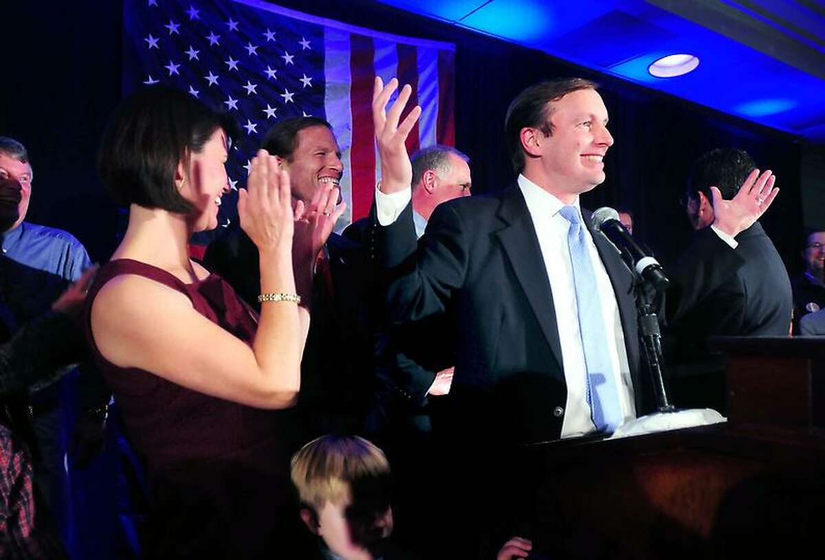 Cathy Murphy, left, applauds her husband, Chris Murphy, as he approaches the podium to declare victory over Linda McMahon at the Hilton Hotel in Hartford on Tuesday. Arnold Gold/New Haven Register