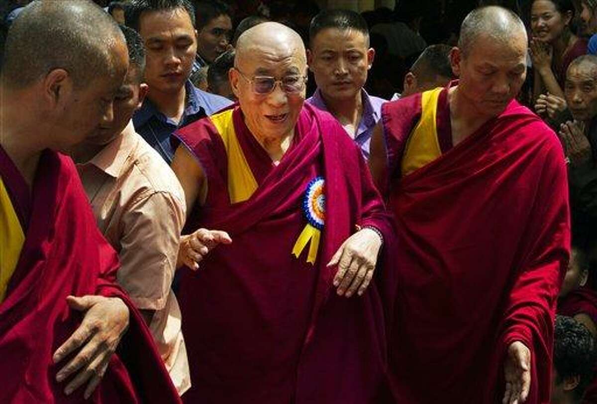 Tibetan spiritual leader, the Dalai Lama, center, is escorted by Tibetan monks as he leaves Tsuglakhang temple in Dharmsala, India, Friday. The Dalai Lama celebrates his 77th birthday with festivities held for the entire day at the temple complex. Associated Press