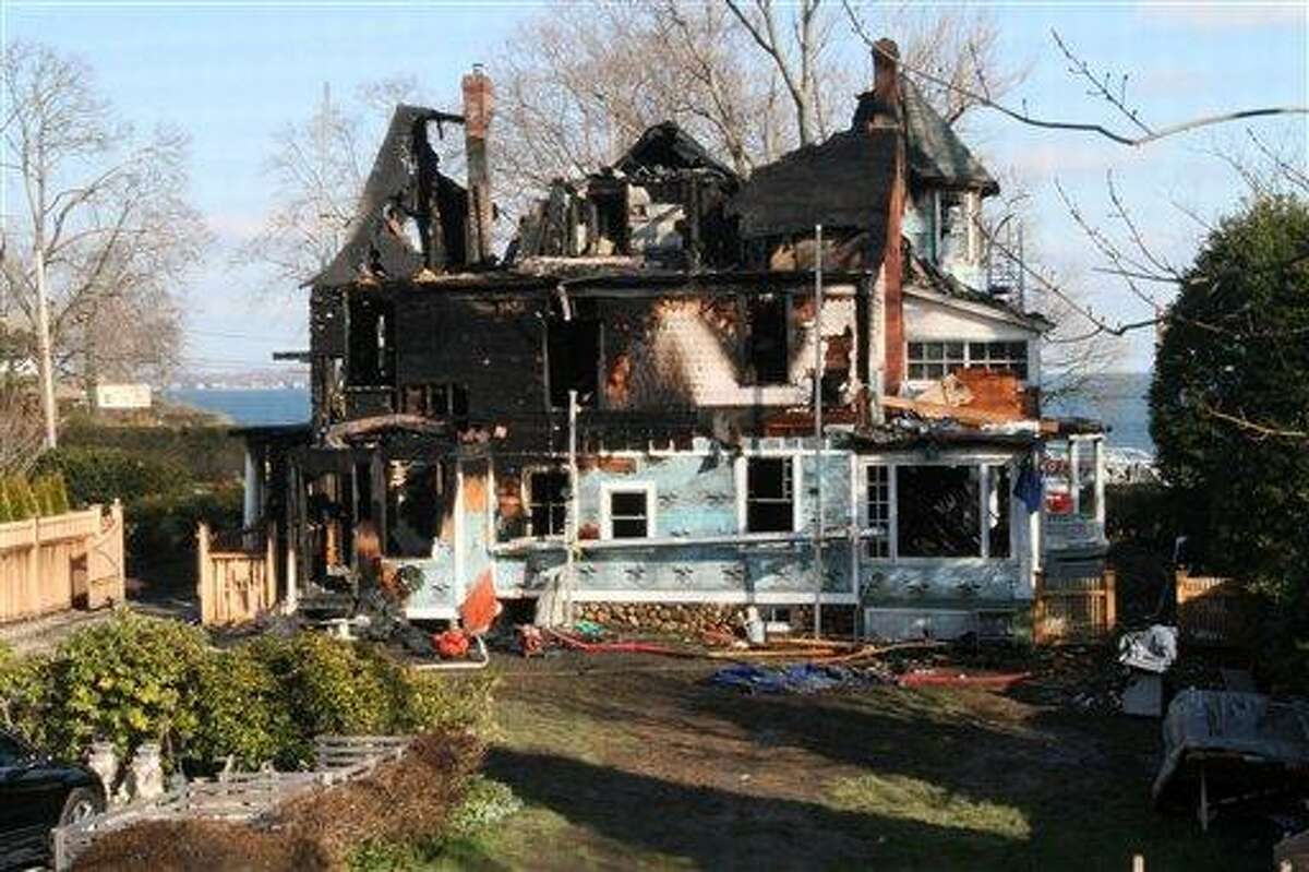 The back of a house where an early morning fire left five people dead is seen Sunday, Dec. 25, 2011, in Stamford, Conn. Officials said the fire, which was reported shortly before 5 a.m., killed two adults and three children. Two others escaped. Their names have not been released. (AP Photo/Tina Fineberg)