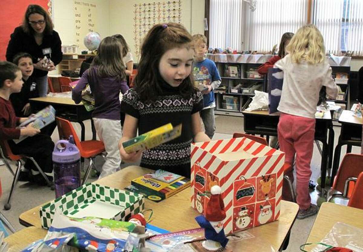 DEBBI MORELLO/ Register Citizen Chelsey Gdovin admires her Christmas present during her first grade class Christmas party at Barkhamsted School on Friday.