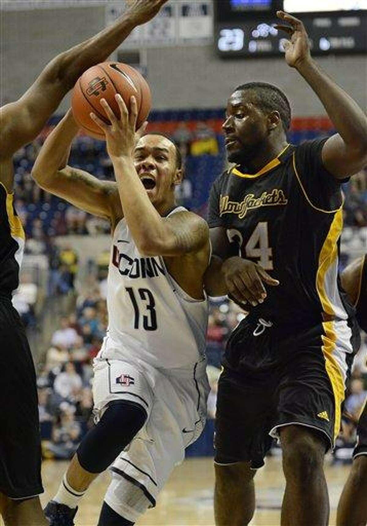 Connecticut Shabazz Napier (13) drives to the basket while guarded by American International College's David Campbell (34) during the first half of a men's NCAA basketball game in Storrs, Conn., Thursday, Nov. 1, 2012. (AP Photo/Jessica Hill)
