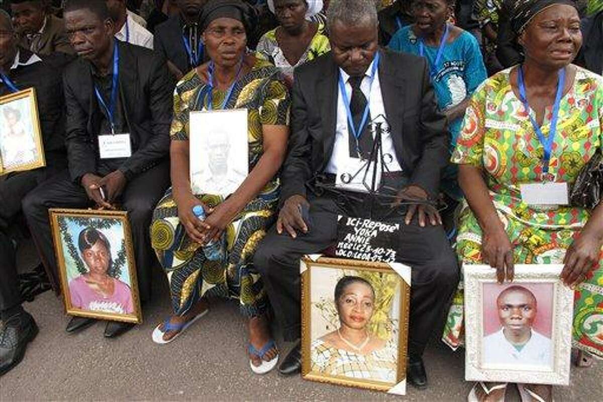 Families hold the portraits of their dead relatives during a mass funeral in Brazzaville, Republic of Congo Sunday for some of the victims of the catastrophic explosion March 4, which left at least 246 dead. A fire inside the main military arms depot caused a series of blast so strong that houses were flattened, crushing scores of people. Only 159 of the bodies could be identified in time for the mass funeral. Associated Press