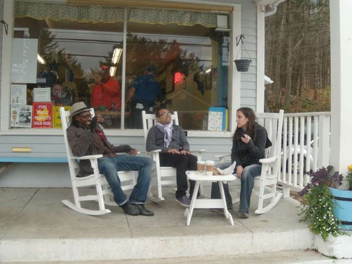 greg seigle/register citizen "This is the life," said Fritz Ravanes, center, as he sits in a rocking chair on the porch of the Cornwall General Store in Cornwall Friday. Ravanes and Niger Miles, left, and Shazdeh Omari, right, were among 17 New Yorkers who fled the city and its storm-related troubles and sought refuge in a rented country cabin for the weekend.