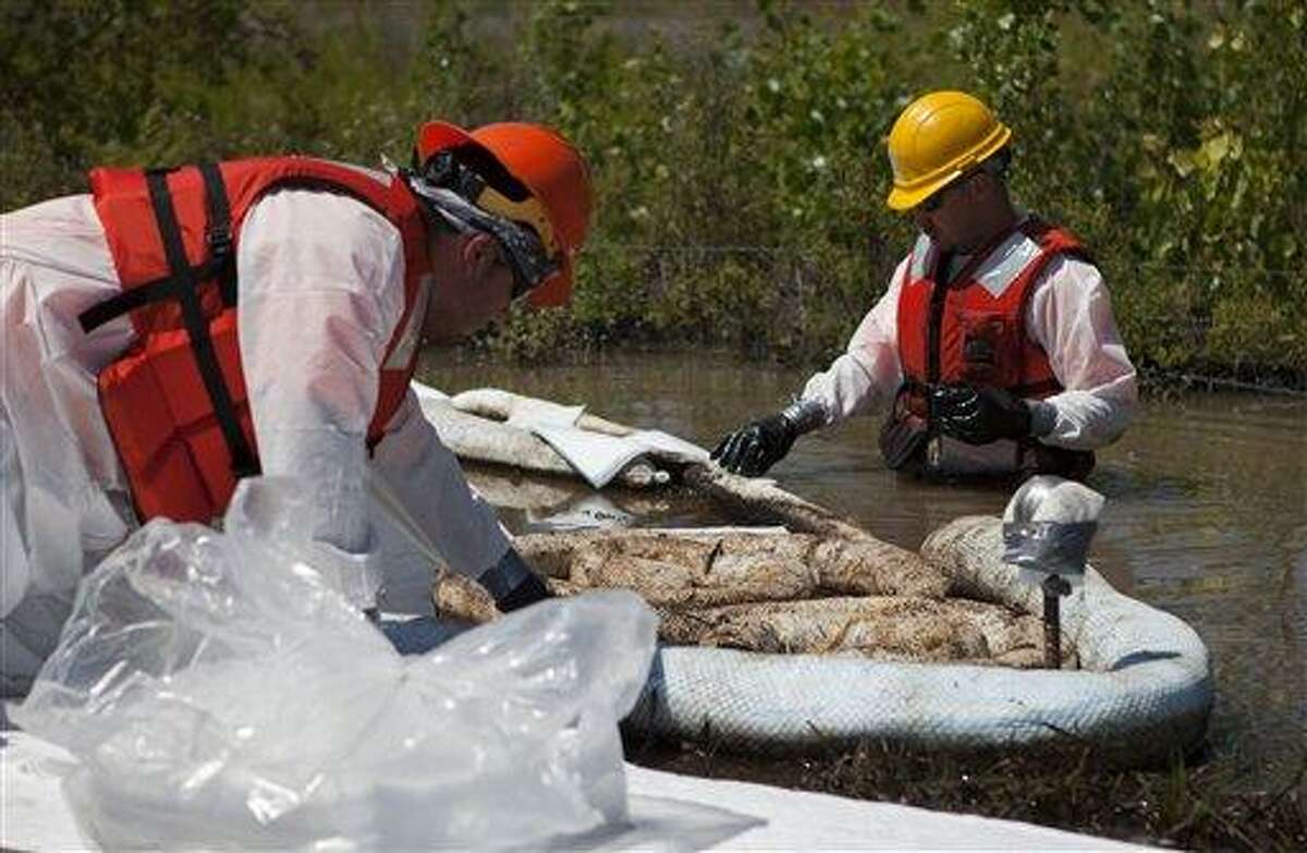 Cleanup workers use oil absorbent materials along side the Yellowstone River in Laurel, Montana, Wednesday July 6, 2011. An Exxon Mobil pipeline near Laurel, Montana ruptured and spilled an estimated 1,000 barrels of crude into the Yellowstone. (AP Photo/Jim Urquhart)