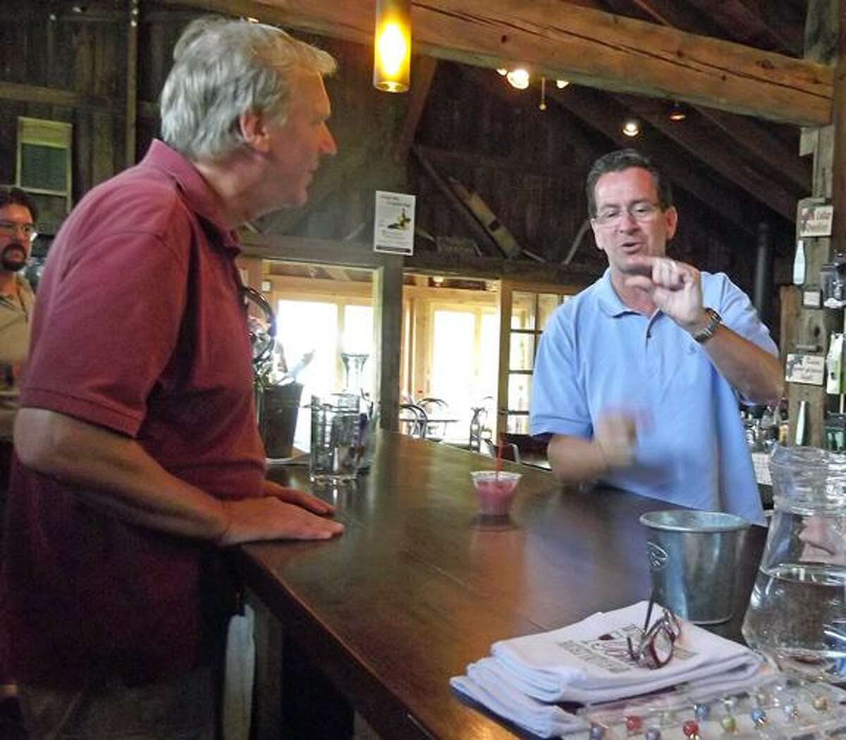 Governor Dannel P. Malloy, in Goshen Monday as part of his promote tourism tour, tells George Motel how much of a taste of wine he wants. Motel is the founder and wine maker at Sunset Meadow Vineyards, the last stop on the governor's five-stop tour. (MICHELLE MERLIN / Register Citizen)