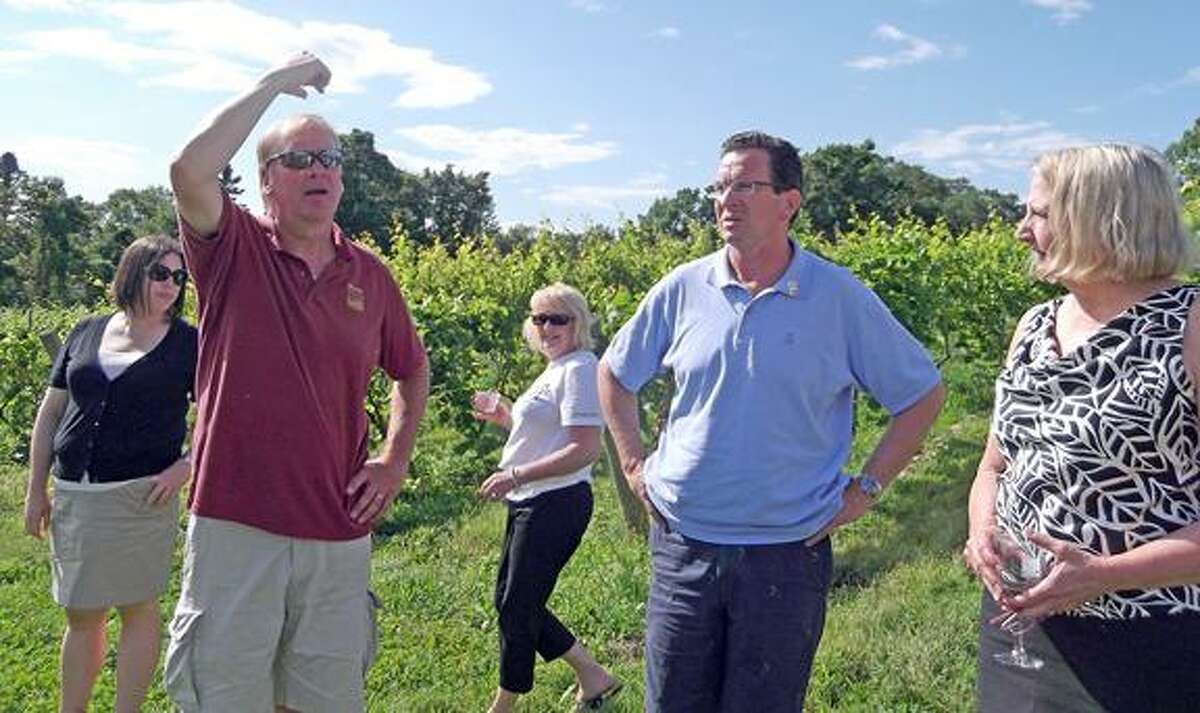 George Motel, the founder and wine maker at Sunset Meadow Vineyards, shows the governor different varieties of grapes at the vineyard. (MICHELLE MERLIN/Register Citizen)