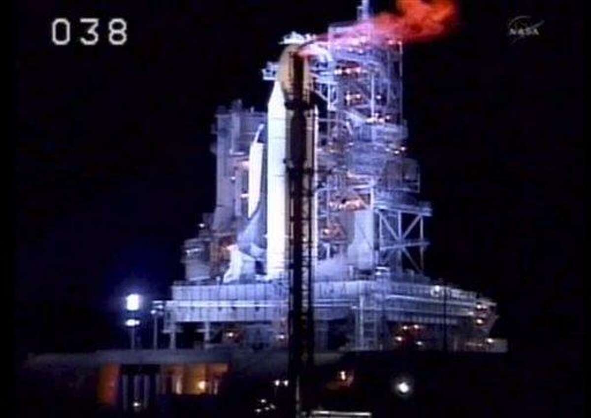 In this image provided by NASA television a fire can be seen at the end of the flare stack that vents the hydrogen portion of the external fuel tank as fueling operations continue for Space Shuttle Atlantic early Friday July 8, 2011. The vented hydrogen is normally burned but the flame is rarely seen. Atlantis is on schedule for liftoff Friday although weather continues to threaten to delay the launch. (AP Photo/NASA