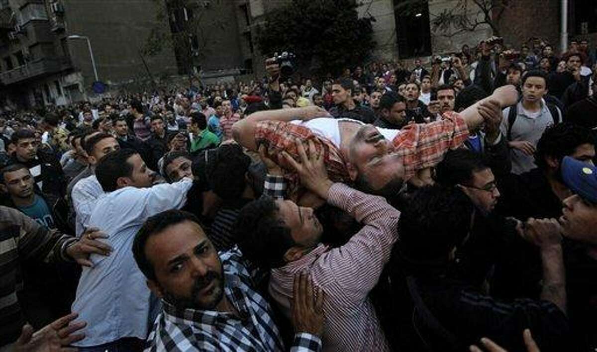 An injured man is evacuated from the burning Interior Ministry complex in Cairo, Egypt, Tuesday, March 22, 2011. An Egyptian security official says police protesting in front of Egypt's Interior Ministry have set fire to part of the downtown complex. The official says protesters lit Tuesday's fire in the building housing in the ministry's personnel department. It then spread to an adjacent building. The fire followed a protest by thousands of low-ranking police officers calling for better wages and working conditions. (AP Photo/Nasser Nasser)