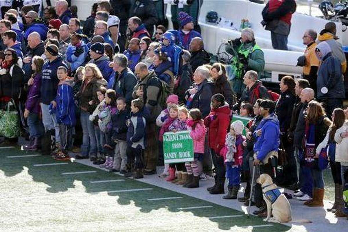 A contingent of teachers, parents, and students from Sandy Hook Elementary School in Newtown, Conn., take part in ceremonies before Sunday's game between the New York Giants and the Philadelphia Eagles at MetLife Stadium, Sunday, Dec. 30, 2012, in East Rutherford, N.J. The school was the site of a mass shooting on Dec. 14. (AP Photo/Peter Morgan)