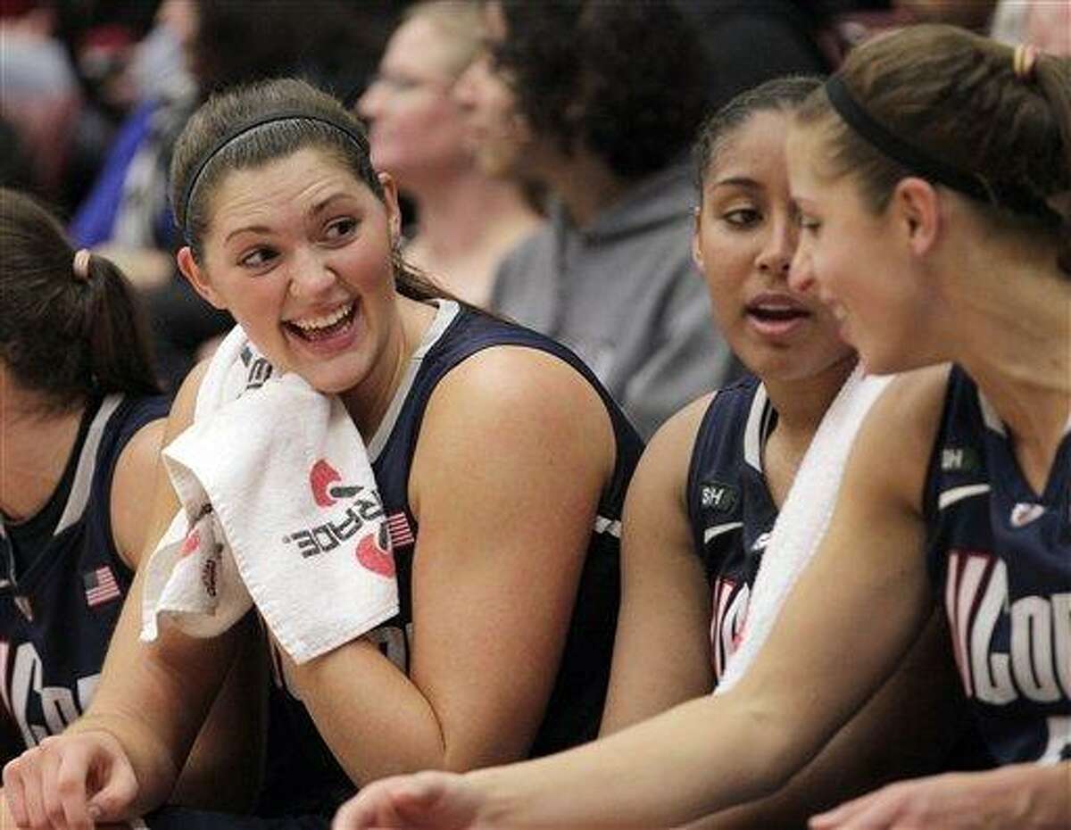 Connecticut center Stefanie Dolson, left, Kaleena Mosqueda-Lewis, center, and Caroline Doty, right, chat on the bench during the second half of their 61-45 victory against Stanford in an NCAA college basketball game in Stanford, Calif., Saturday, Dec. 29, 2012. (AP Photo/Tony Avelar)