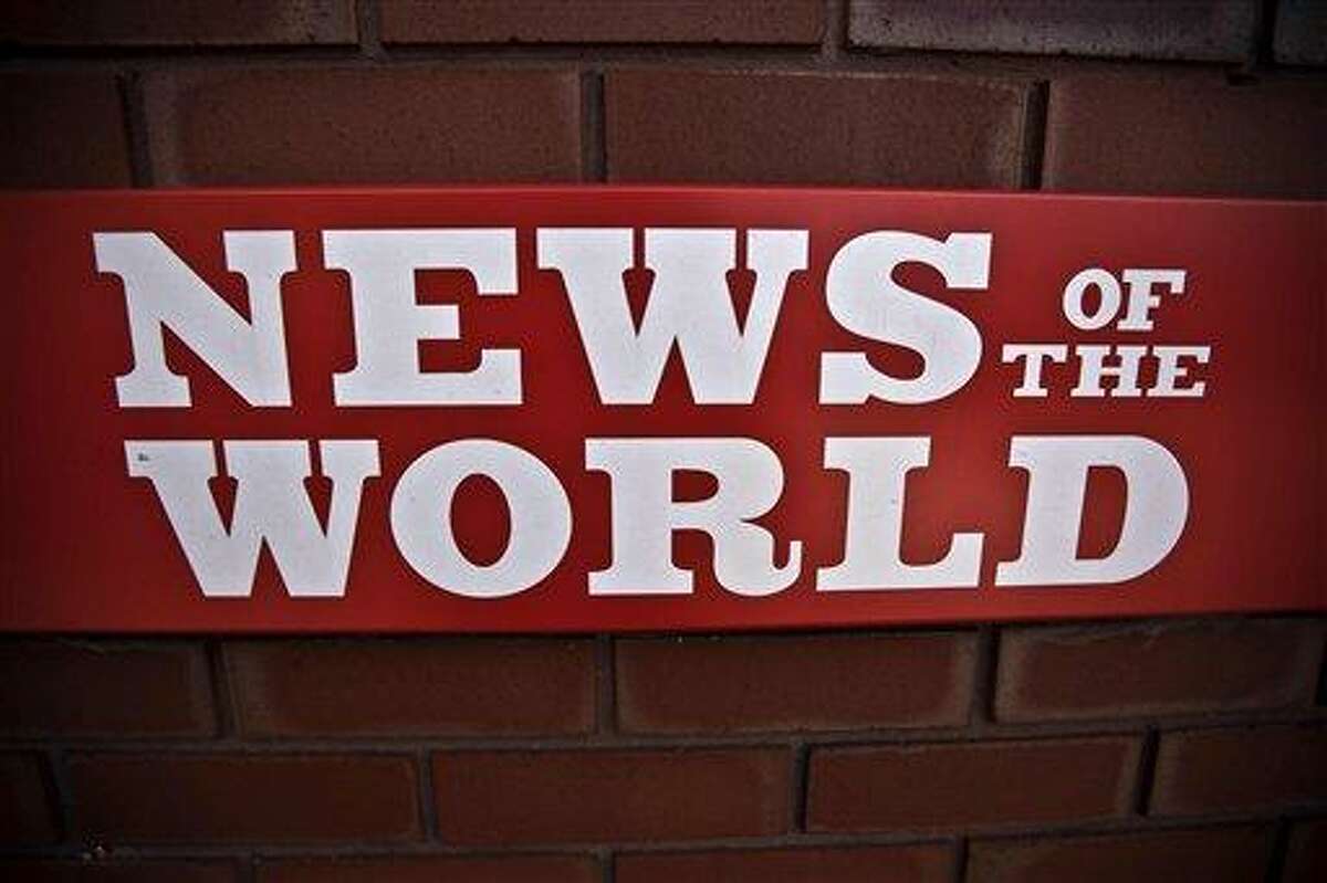 FILE - This is a Wednesday, July 6, 2011 file photo of a News of the World sign is seen by an entrance at premises of News International in London. James Murdoch News Corporation executive says the News of the World will publish its last issue on Sunday. The focus of the phone hacking scandal shifted Thursday to serious allegations of police corruption as Scotland Yard called for an independent review of reported payoffs by journalists to police. The review announced Thursday by the Independent Press Complaints Commission reflects the seriousness of the corruption charges, which are apparently based on information provided by the embattled News of the World tabloid to police in recent days. (AP Photo/Matt Dunham)