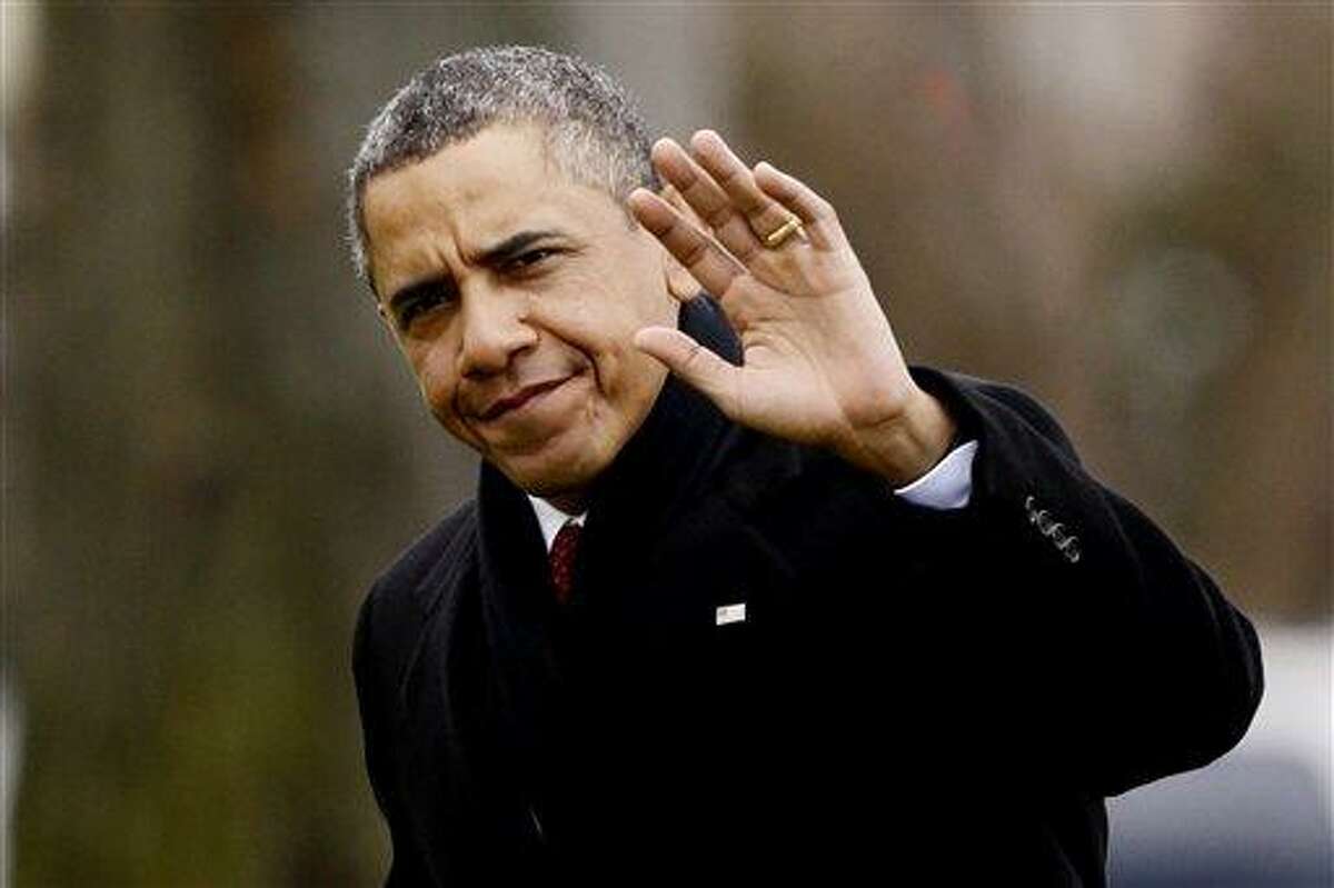 President Barack Obama waves to reporters as he steps off the Marine One helicopter and walks on the South Lawn Thursday at the White House in Washington, as he returns early from his Hawaii vacation for meetings on the fiscal cliff. Associated Press