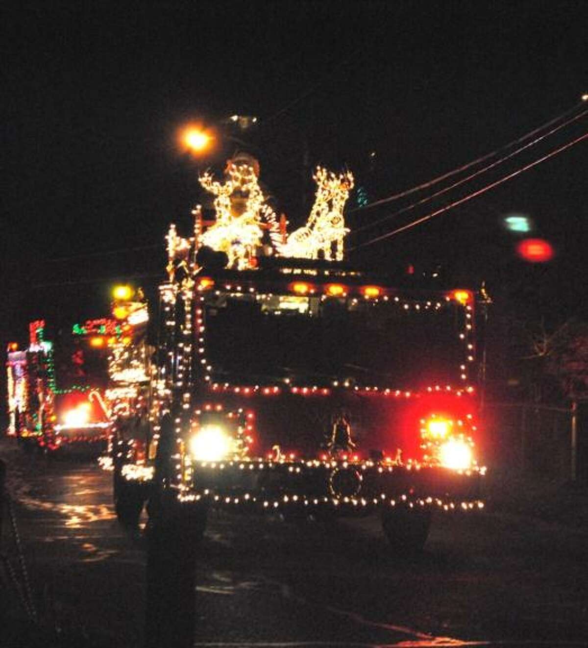 MIKE AGOGLIATI/Register Citizen A Winsted firetruck, decorated for the holidays, makes its way around the lake in the eight annual Gator Parade.