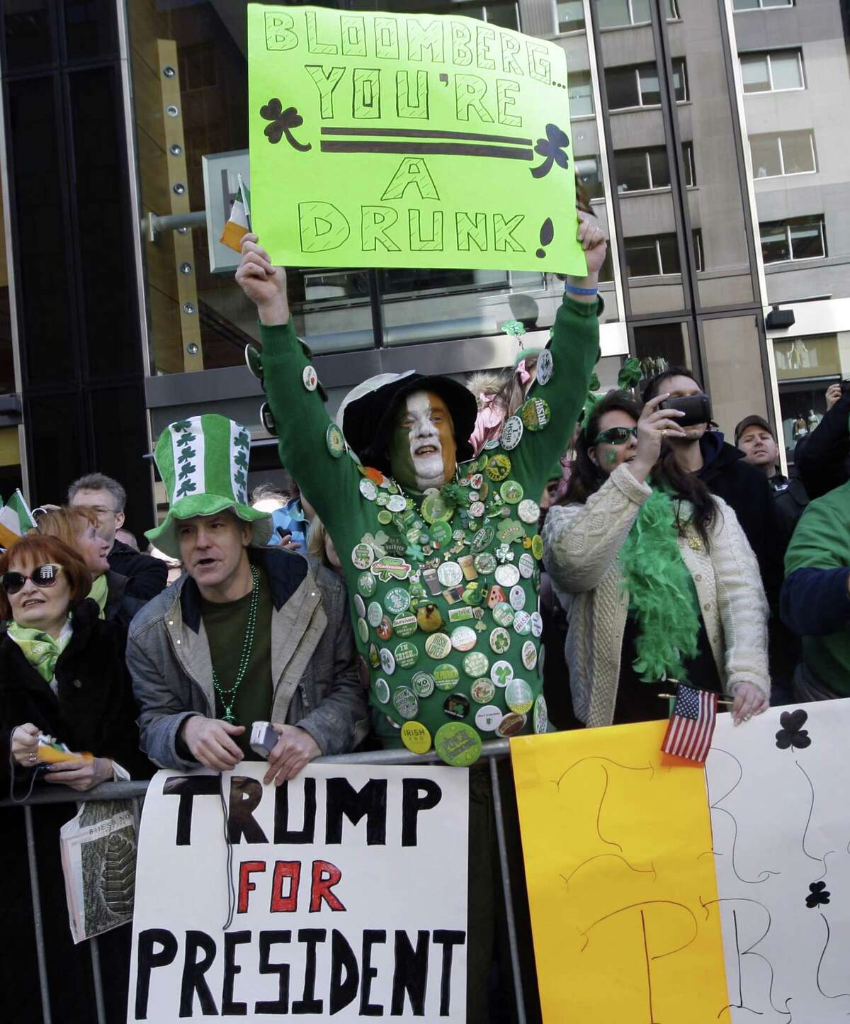 In this March 17, 2011, file photo spectators along the parade route at New York's annual St. Patrick's Day parade show their political feelings in signs, including one favoring 64-year-old real estate tycoon Donald Trump for president. Trump says he'll make a decision by June on whether to join the field of GOP contenders vying to challenge Obama in 2012.