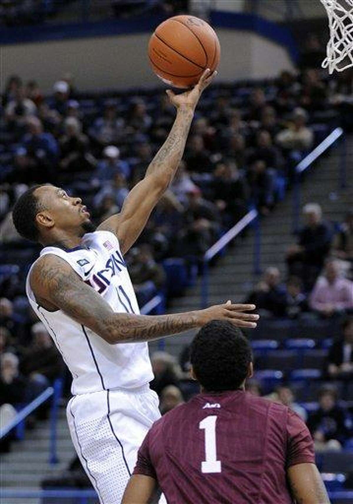 Connecticut's Ryan Boatright, left, drives to the basket as Fordham's Branden Frazier looks on during the first half of an NCAA college basketball game in Hartford, Conn., Friday, Dec. 21, 2012. Boatright and Frazier each scored a game-high 26 points in Connecticut's 88-73 victory. (AP Photo/Fred Beckham)