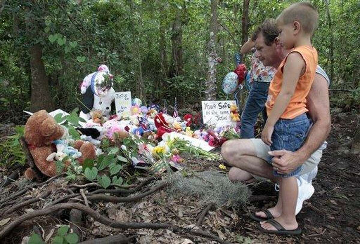 Alan Holt and his grandson Mark Likins, of Thomasville, Ga., visit the memorial of Caylee Anthony before Casey Anthony was found not guilty of first-degree murder, aggravated manslaughter and aggravated child abuse. in Orlando, Fla., Tuesday, July 5, 2011. (AP Photo/Alan Diaz)
