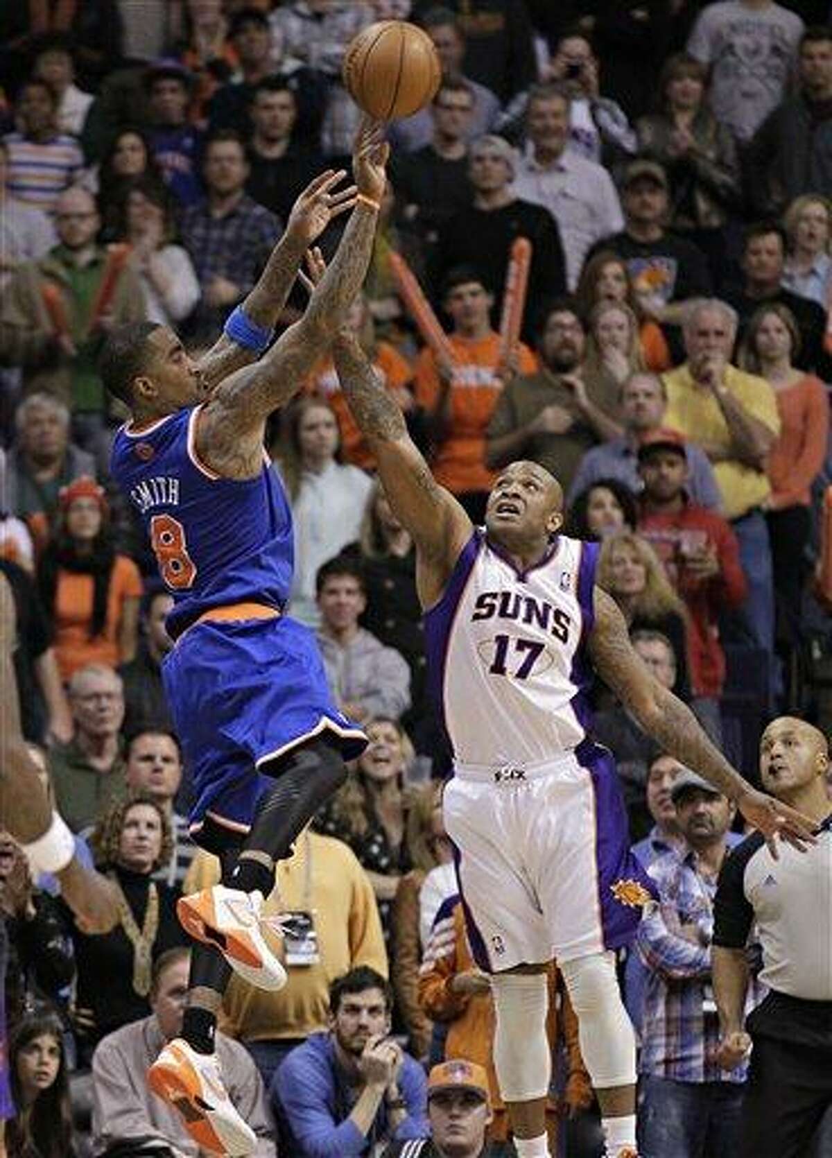 New York Knicks' J.R. Smith (9) takes the game-winning shot over Phoenix Suns' P.J. Tucker (17) during the second half of an NBA basketball game, Wednesday, Dec. 26, 2012, in Phoenix. The Knicks won 99-97. (AP Photo/Matt York)