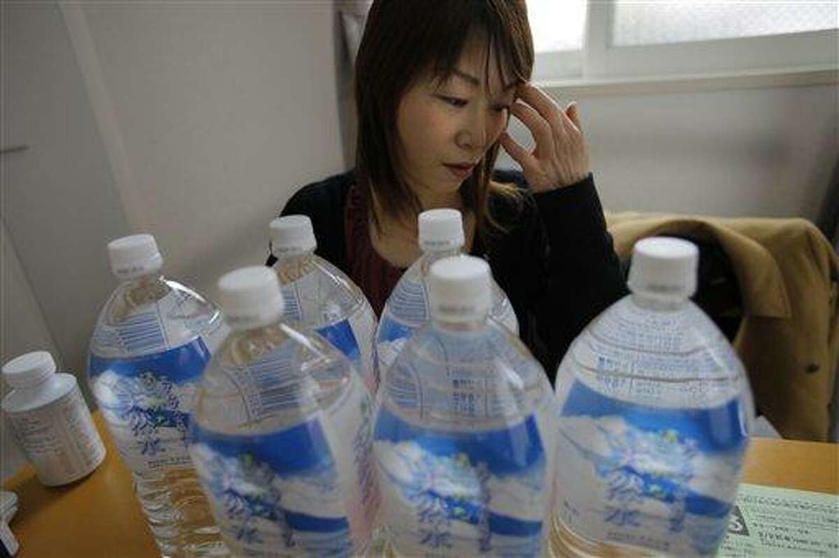 In this February photo, Yoshiko Ota displays the bottled water she bought at a local shop for daily use at her house in Fukushima, Japan. Ota keeps her windows shut. She never hangs her laundry outdoors. Fearful of birth defects, she warns her daughters: Never have children. This is life with radiation, nearly one year after a tsunami-hit nuclear power plant began spewing it into Ota's neighborhood, 40 miles (60 kilometers) away. Associated Press