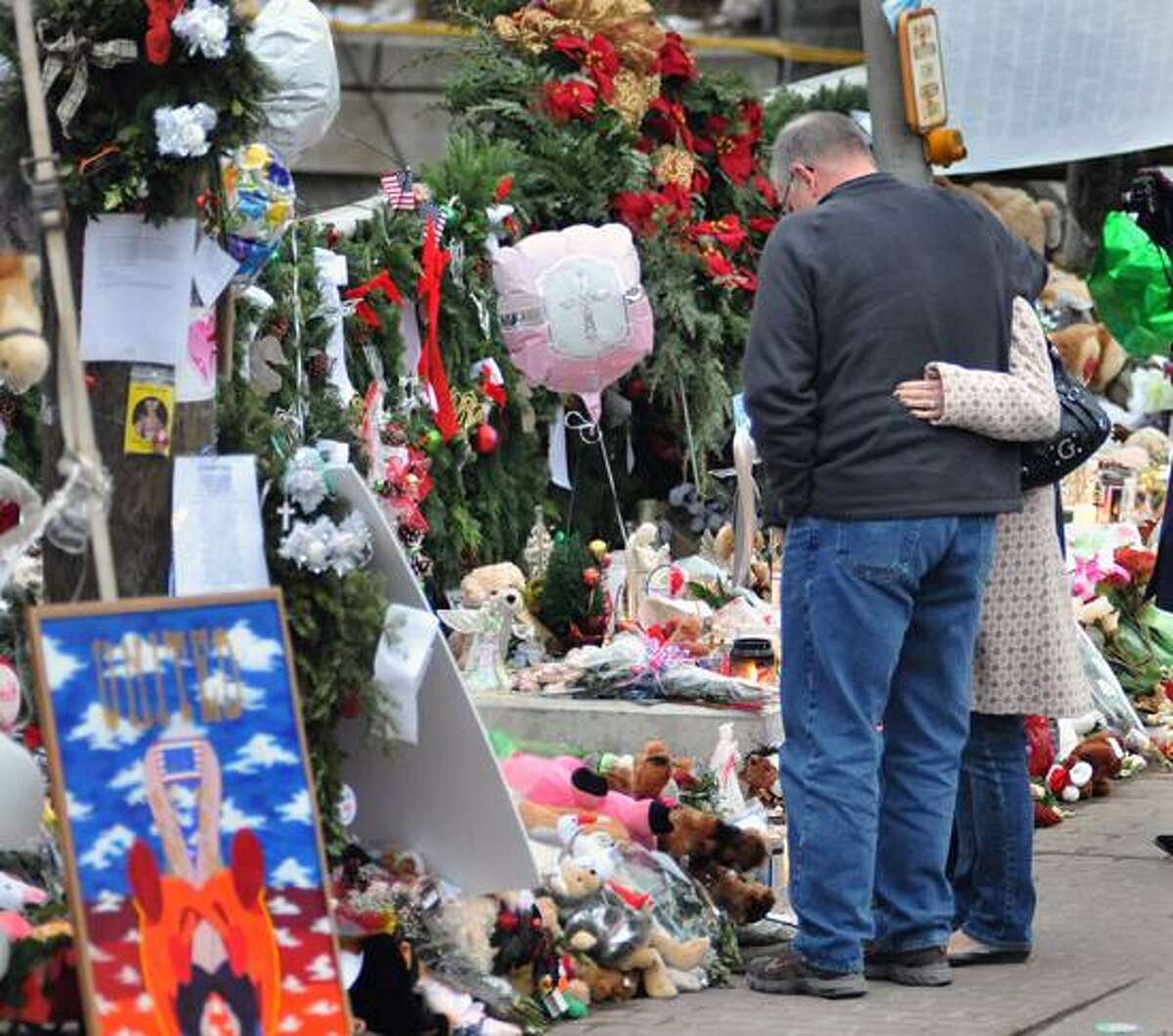Sandy Hook-- People look over the ever growing memorials in the center of Sandy hook on Weds. Photo-Peter Casolino 12/26/12,