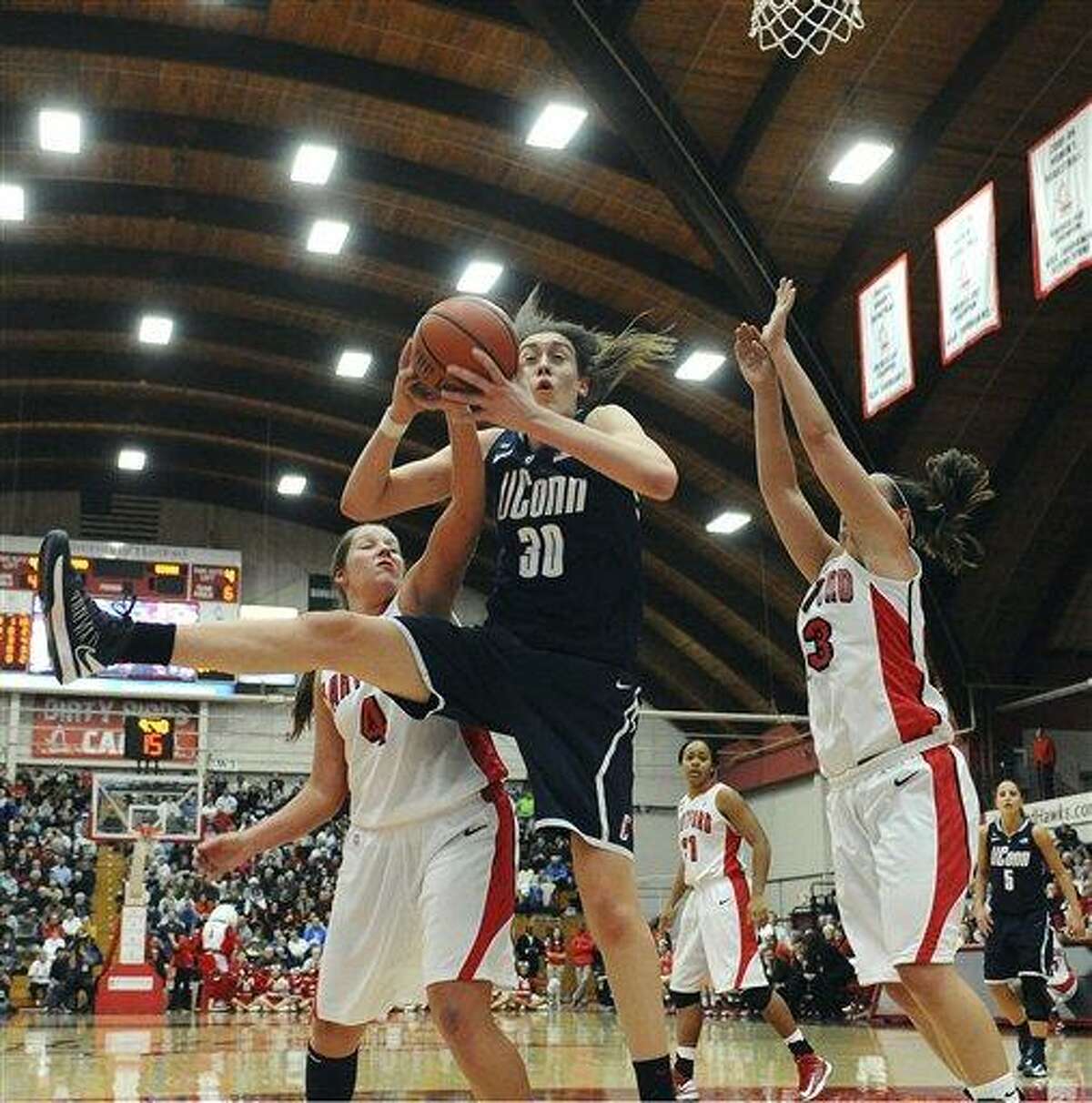 Connecticut's Breanna Stewart, center, snags a rebound while guarded by Hartford's Christie Michals, left, and Taylor Clark, right, during the second half of an NCAA women's college basketball game in West Hartford, Conn., Saturday, Dec. 22, 2012. Connecticut won 102-45. (AP Photo/Jessica Hill)