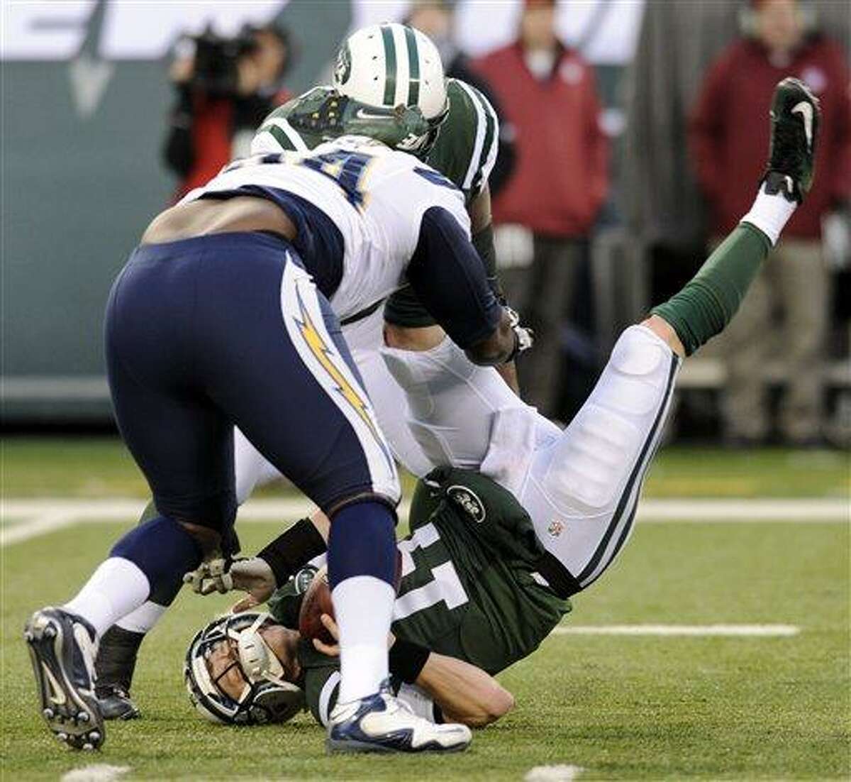 FILE - In this Dec. 23, 2012, file photo, New York Jets quarterback Greg McElroy, bottom, is sacked by San Diego Chargers defensive end Corey Liuget, front left, during the second half of an NFL football game in East Rutherford, N.J. McElroy, who was sacked 11 times last weekend, has a concussion and will be replaced by Mark Sanchez as the Jets' starting quarterback in the season finale at Buffalo on Sunday, coach Rex Ryan said. (AP Photo/Bill Kostroun, File)
