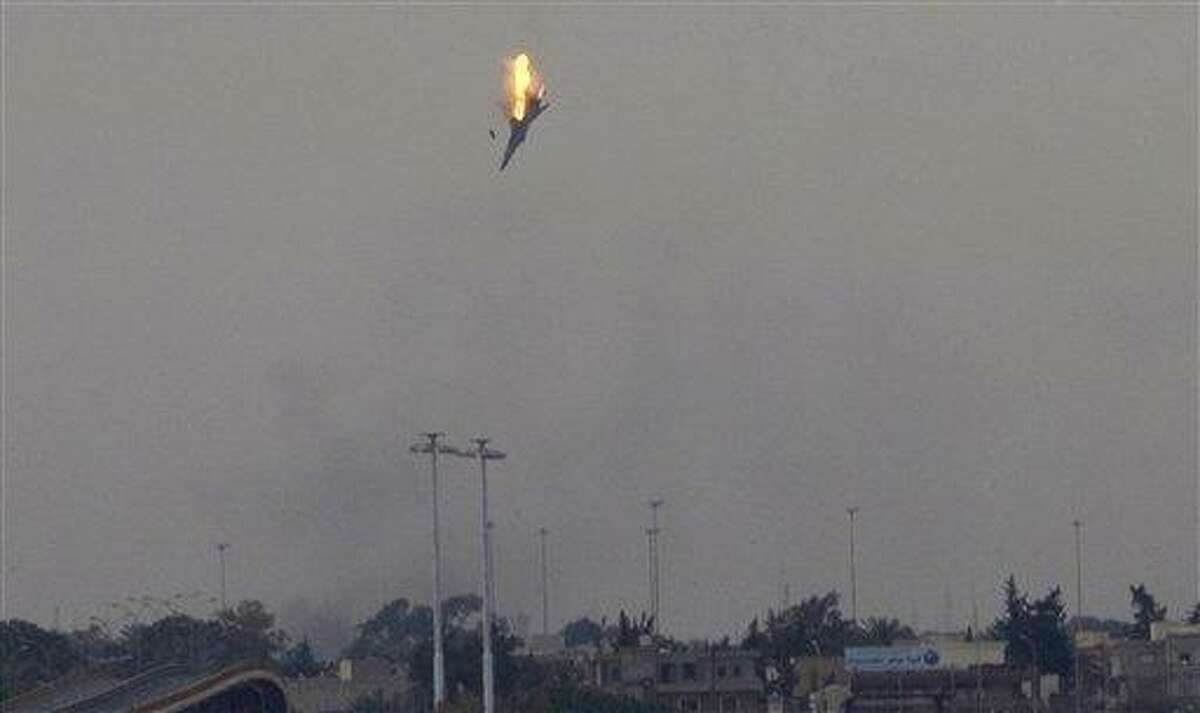WE ARE UNABLE TO VERIFY WHO SHOT PLANE DOWN AND ALSO WHO WAS PILOTING PLANE - A warplane is seen being shot down over the outskirts of Benghazi, eastern Libya, Saturday, March 19, 2011. Explosions shook the Libyan city of Benghazi early on Saturday while a Libyan jet fighter was heard flying overhead, and residents said the eastern rebel stronghold was under attack from Gadhafi's forces.