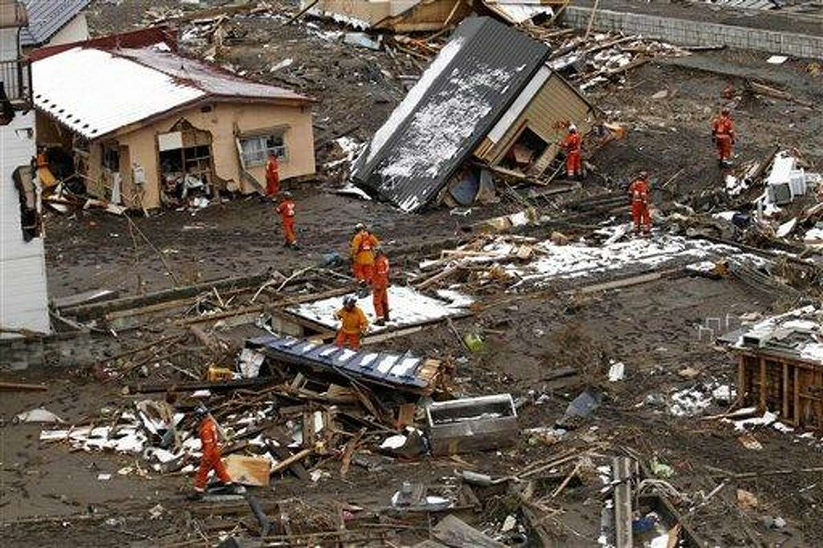 Members of a British search and rescue team works at a devastated area in the aftermath of Friday's tsunami that struck Kamaishi, Japan, Thursday, March 17, 2011. Two search and rescue teams from the U.S. and a team from the U.K. with combined numbers of around 220 personnel are on the recovery operation Thursday to help in the aftermath of the earthquake and tsunami. (AP Photo/Matt Dunham)