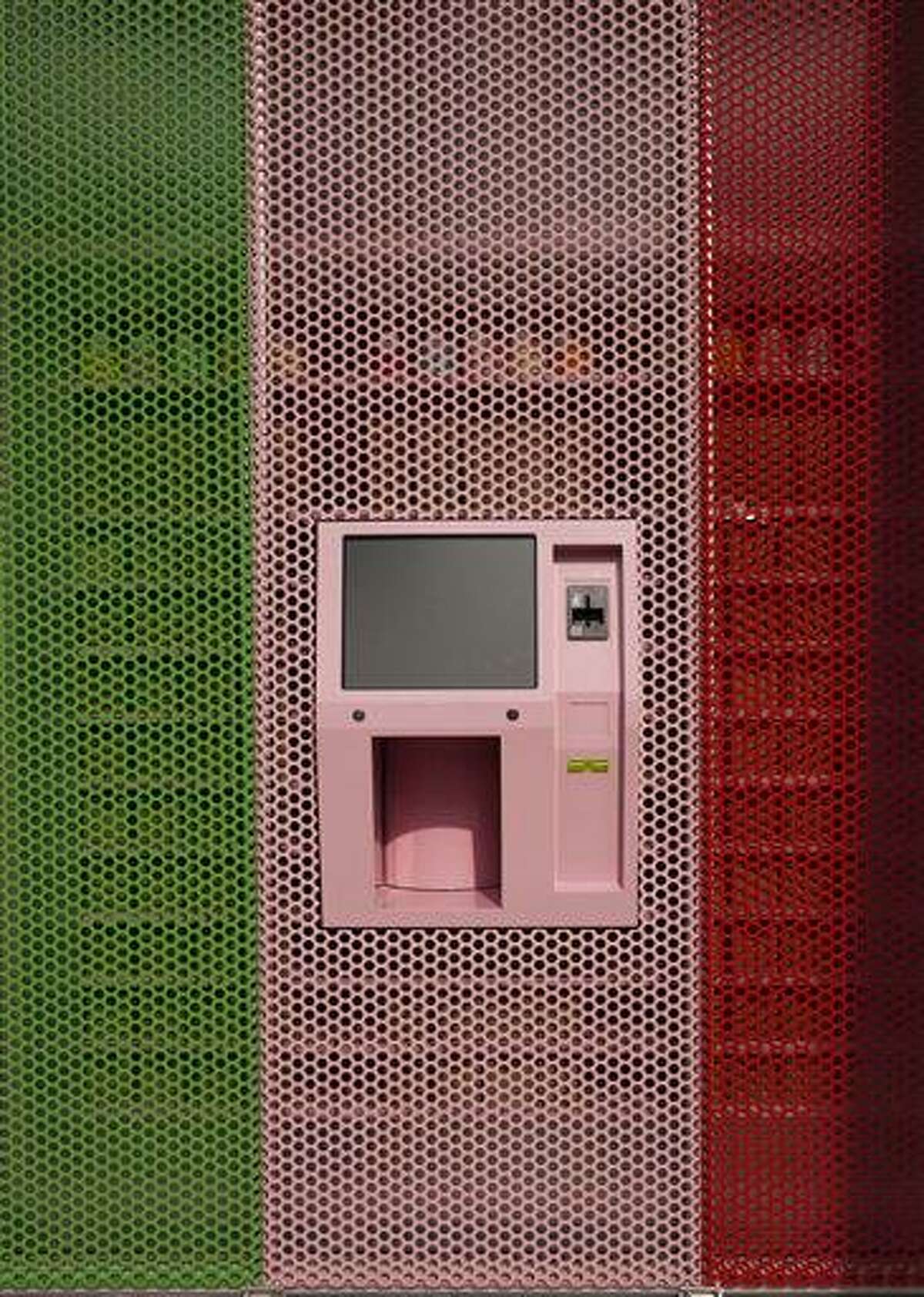 A new 24-hour cupcake "ATM," an automatic machine that will be continuously be restocked to dispense fresh cupcakes is seen at Sprinkles Cupcakes in Beverly Hills, Calif. The machine features a touchscreen and a robotic arm that pulls the right flavored cupcake from a wall of single-serving boxes inside the store. Associated Press