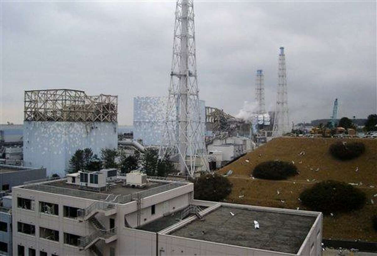 In this image released by Tokyo Electric Power Co., smoke billows from the No. 3 unit among four housings cover four reactors at the Fukushima Dai-ichi nuclear complex in Okumamachi, Fukushima Prefecture, northeastern Japan, on Tuesday, March 15, 2011. Japan ordered emergency workers to withdraw from its stricken nuclear complex Wednesday amid a surge in radiation, temporarily suspending efforts to cool the overheating reactors. Hours later, officials said they were preparing to send the team back in. (AP Photo/Tokyo Electric Power Co.)