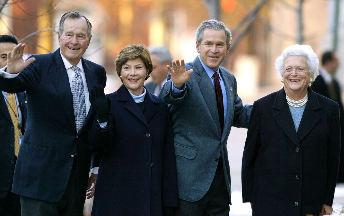 In this Dec. 7, 2003 file photo, former President George H.W. Bush, then first lady Laura Bush, then President George W. Bush, and former first lady Barbara Bush wave to reporters outside St. John's church in Washington. Laura Bush and Barbara Bush are headlining a Dallas conference on first ladies. Presidential historian Doris Kearns Goodwin will moderate a conversation with the former first ladies on Monday. (AP Photo/Evan Vucci, File)